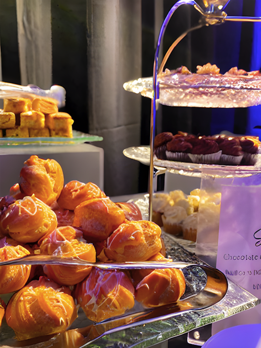 close up shot of cream puffs, cupcakes, and pasties on a tiered tray