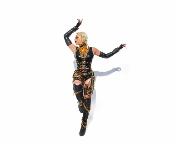 laganja poses in black leather on a white background with arms flung dramatically in the air