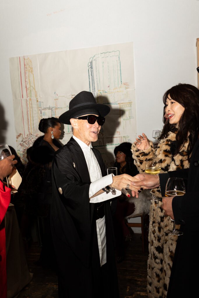 Guests in eveningwear socializing with wine during the Haute Mess winter solstice fashion party