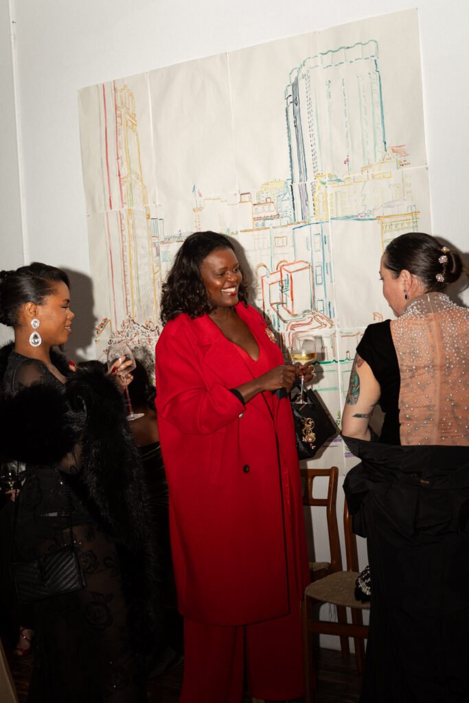 Guests in formal eveningwear chatting and holding wine glasses during the Haute Mess winter solstice party
