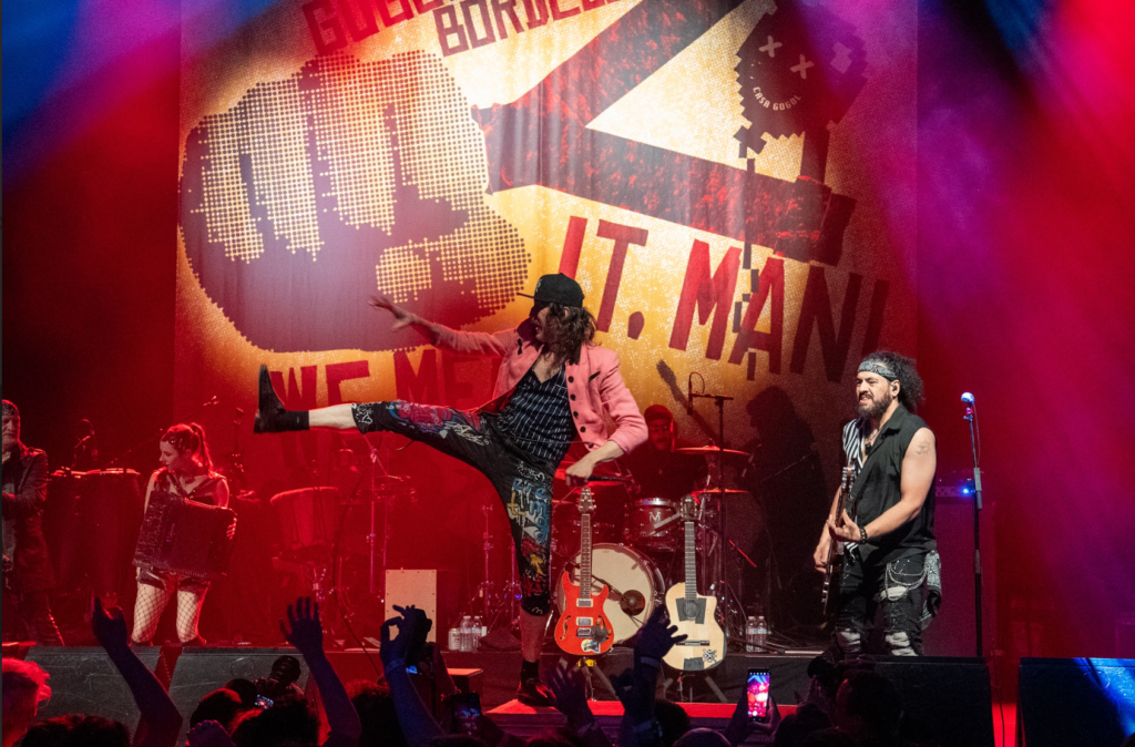 Black and white wide shot of Gogol Bordello performing at The Warfield