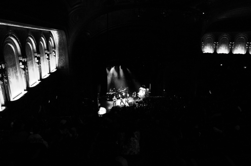 Black and white wide shot of Gogol Bordello performing at The Warfield