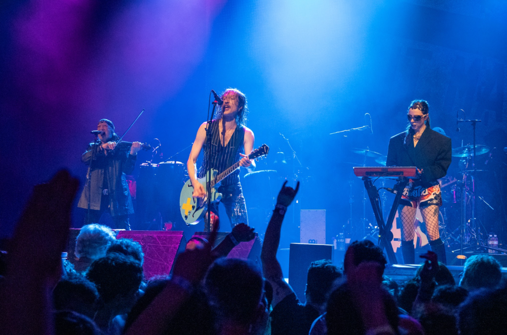 Full band with guest vocalist performing at Gogol Bordello show in San Francisco