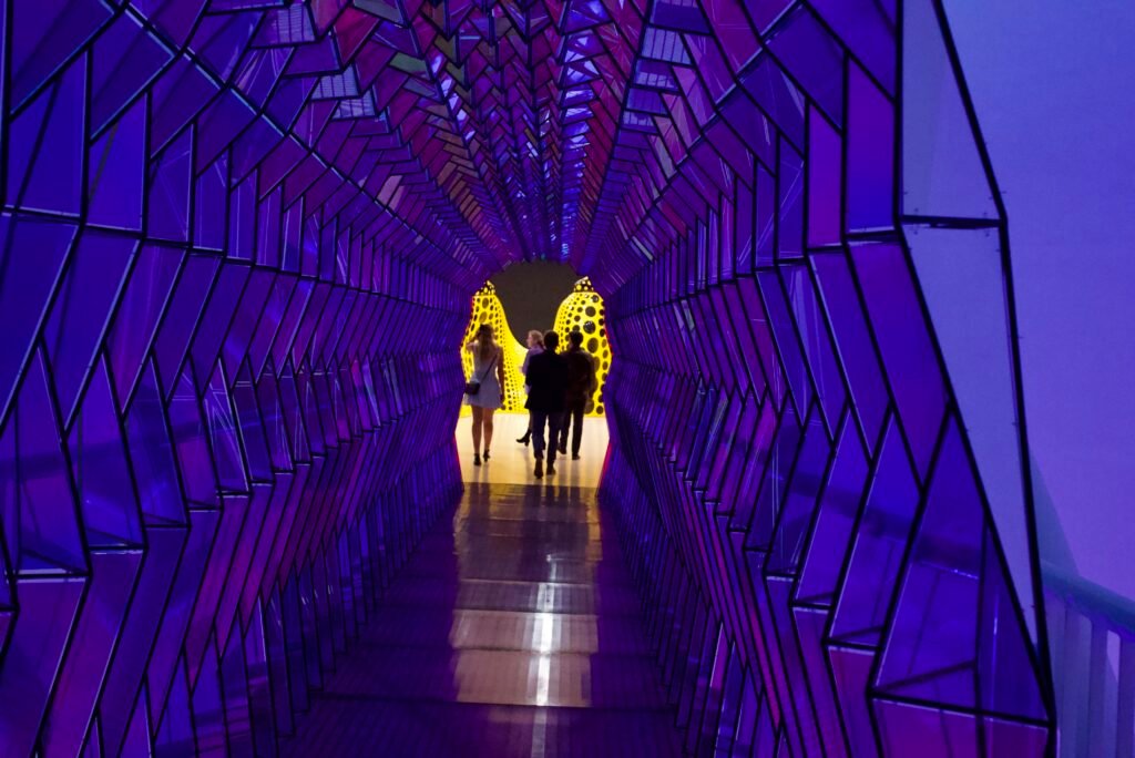 Guests walking through purple geometric tunnel installation at SFMOMA