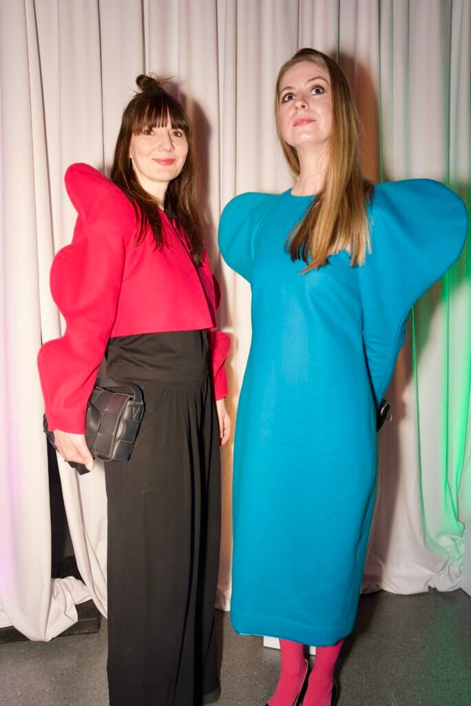 Two guests wearing bold sculptural shoulder designs at SFMOMA Art Bash