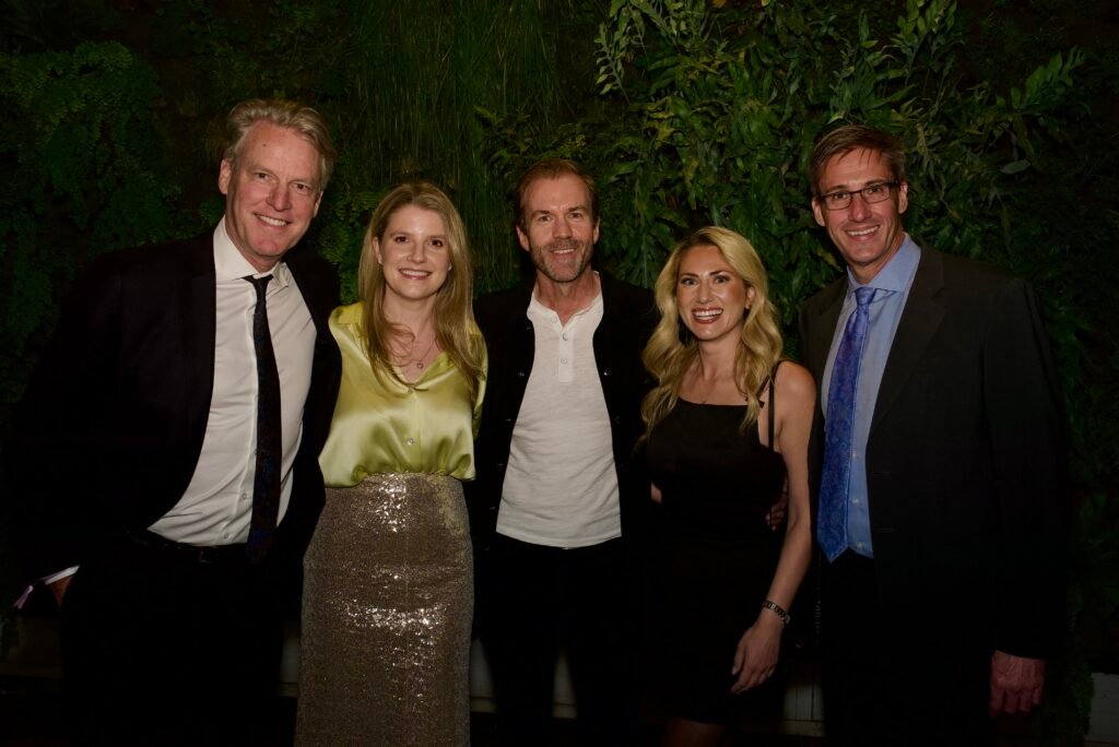 Guests posing in front of green plant wall at SFMOMA