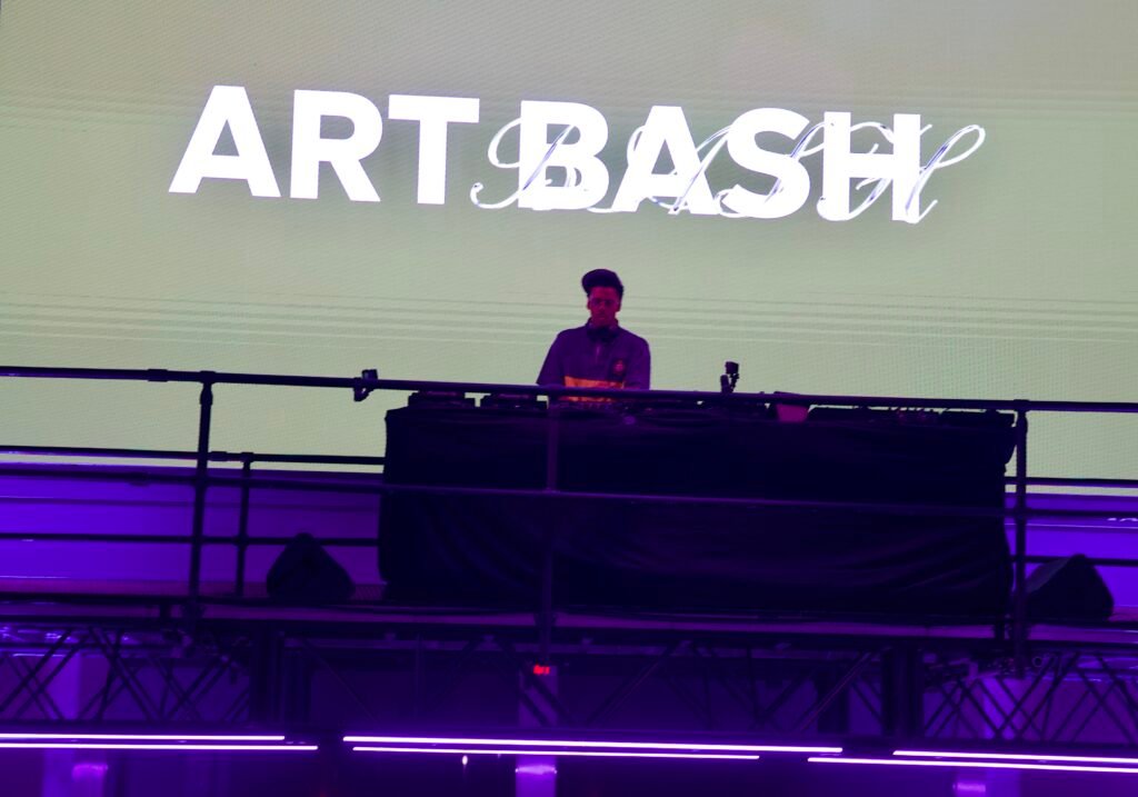 DJ performing under Art Bash projection at SFMOMA