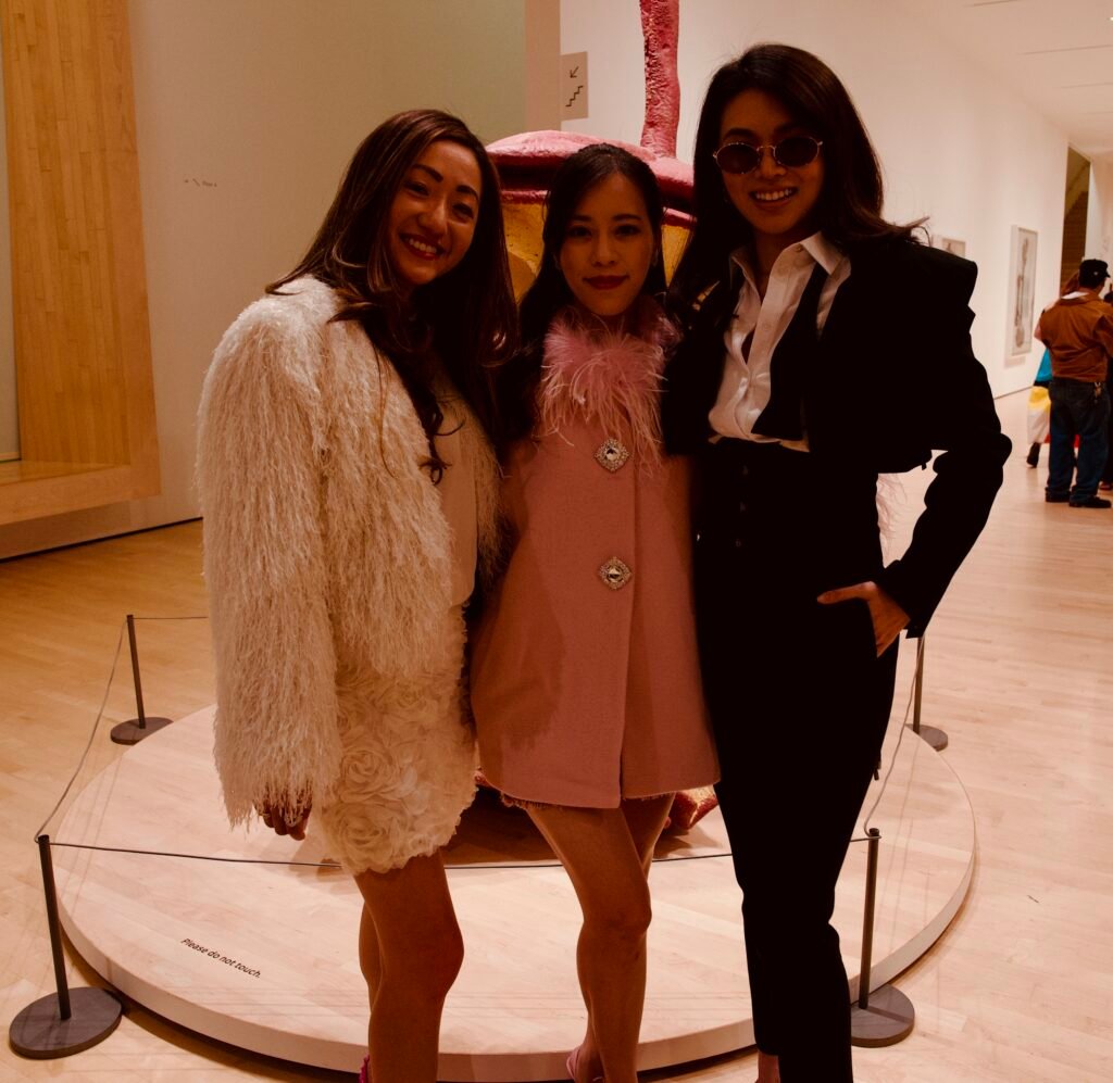 Three guests wearing coordinated soft-toned outfits at SFMOMA Art Bash