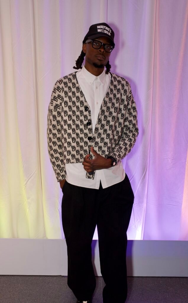 Guest wearing patterned cardigan, white shirt, and cap at SFMOMA Art Bash