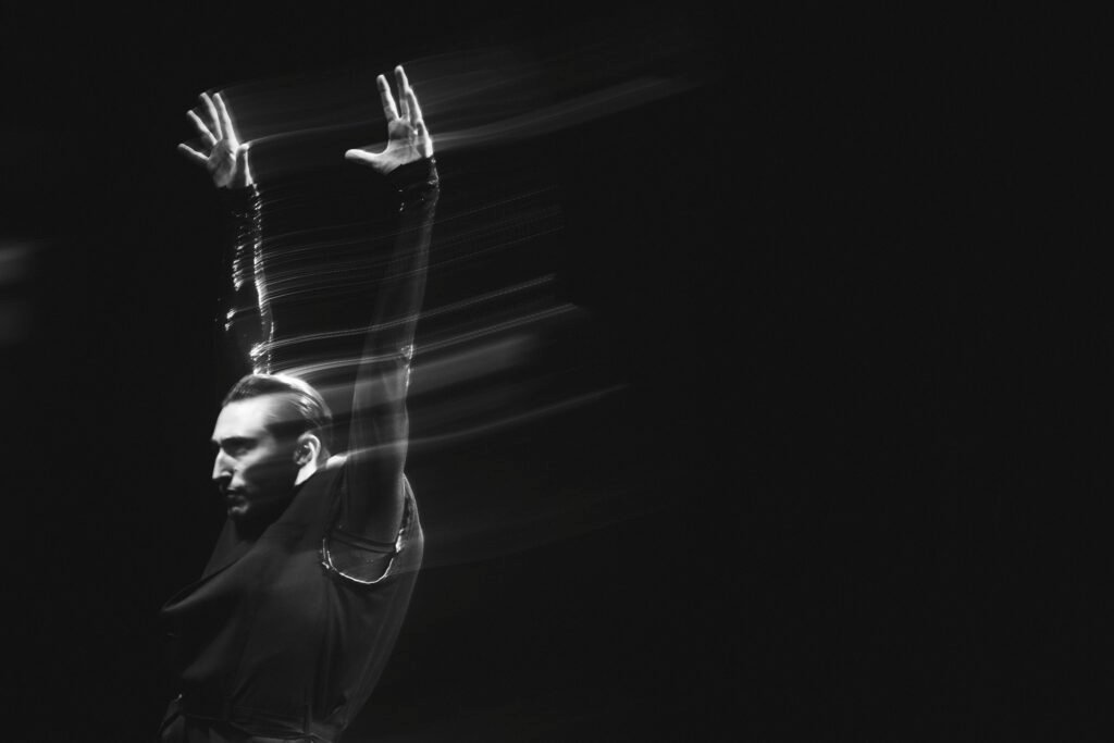 Nathaniel Remez performing in Mere Mortals with arms raised in blurred motion, San Francisco Ballet