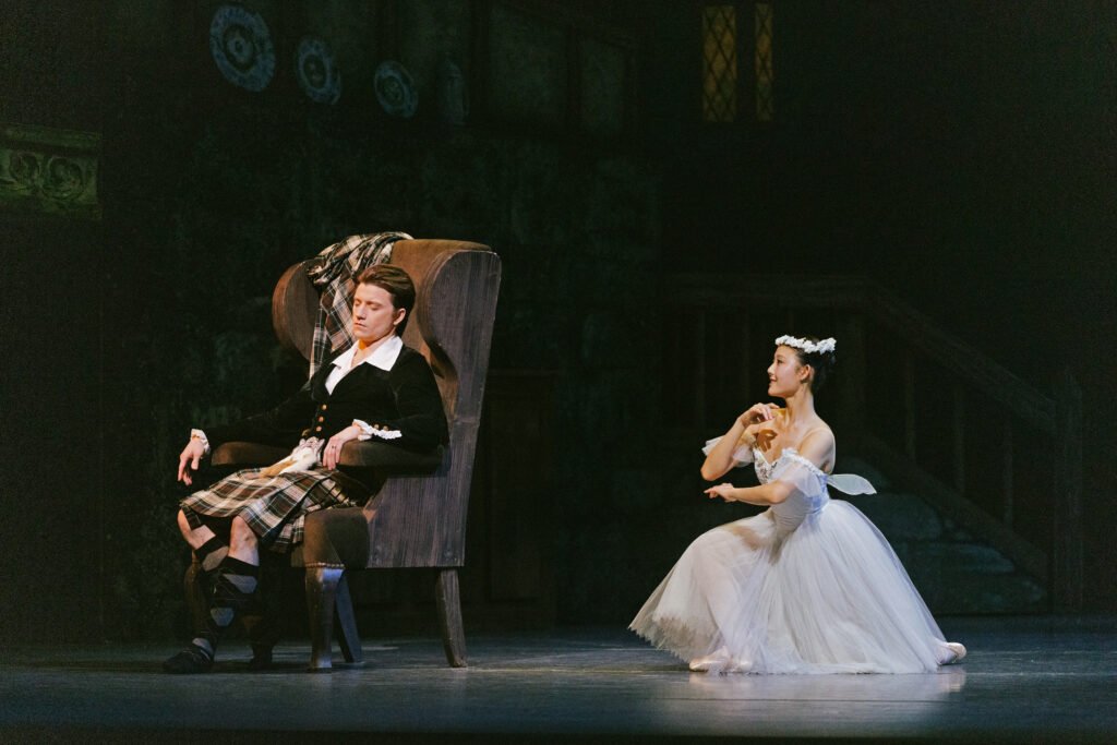James seated while the Sylph kneels beside him in La Sylphide San Francisco Ballet