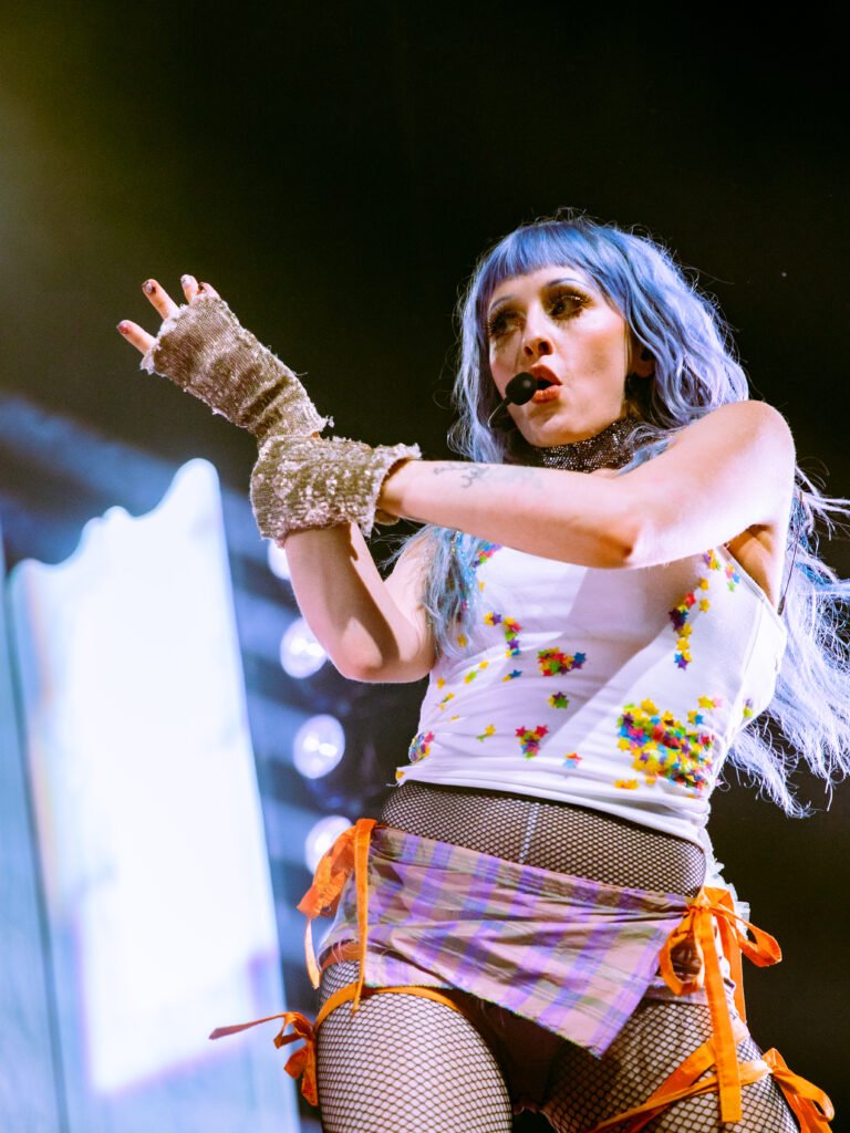Ashnikko performing live with blue hair and headset mic at The Warfield San Francisco