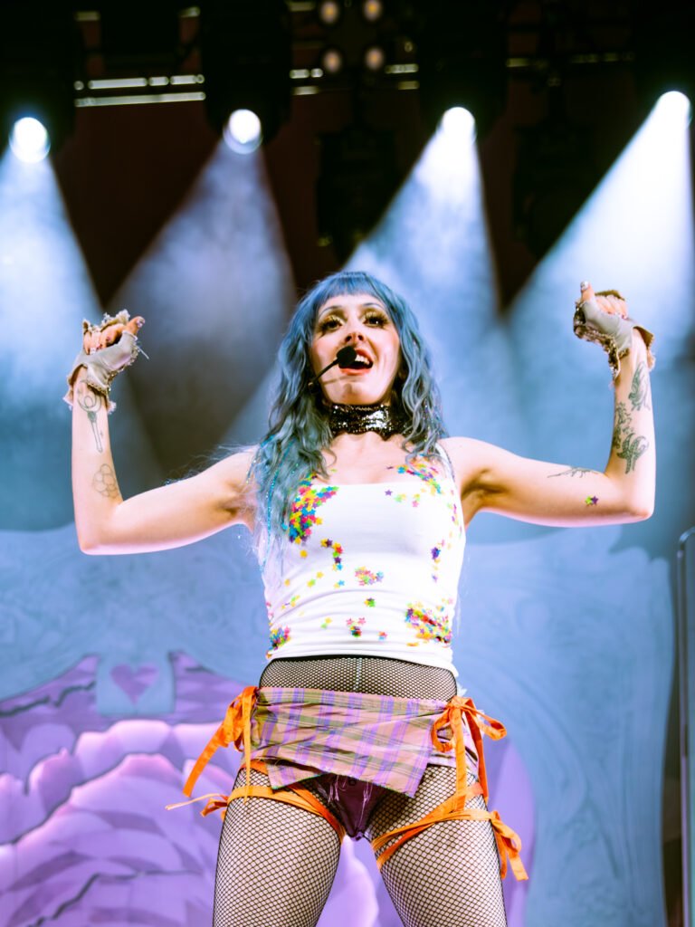 Ashnikko raising arms on stage during live concert performance San Francisco