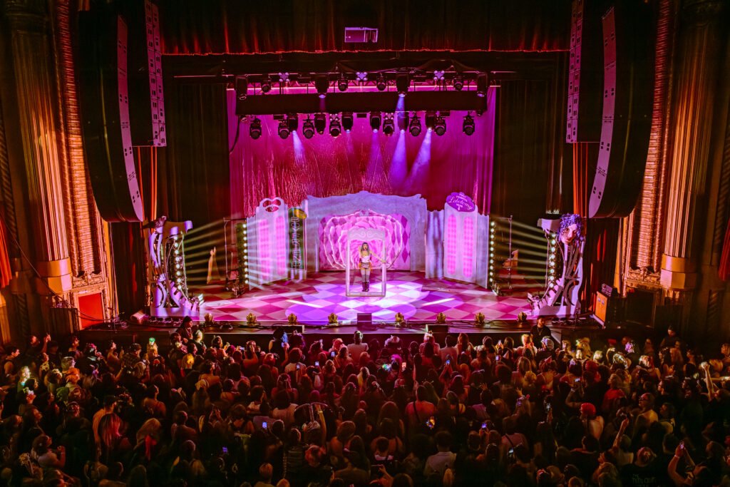 ull stage view of Ashnikko performance with pink lighting and large audience