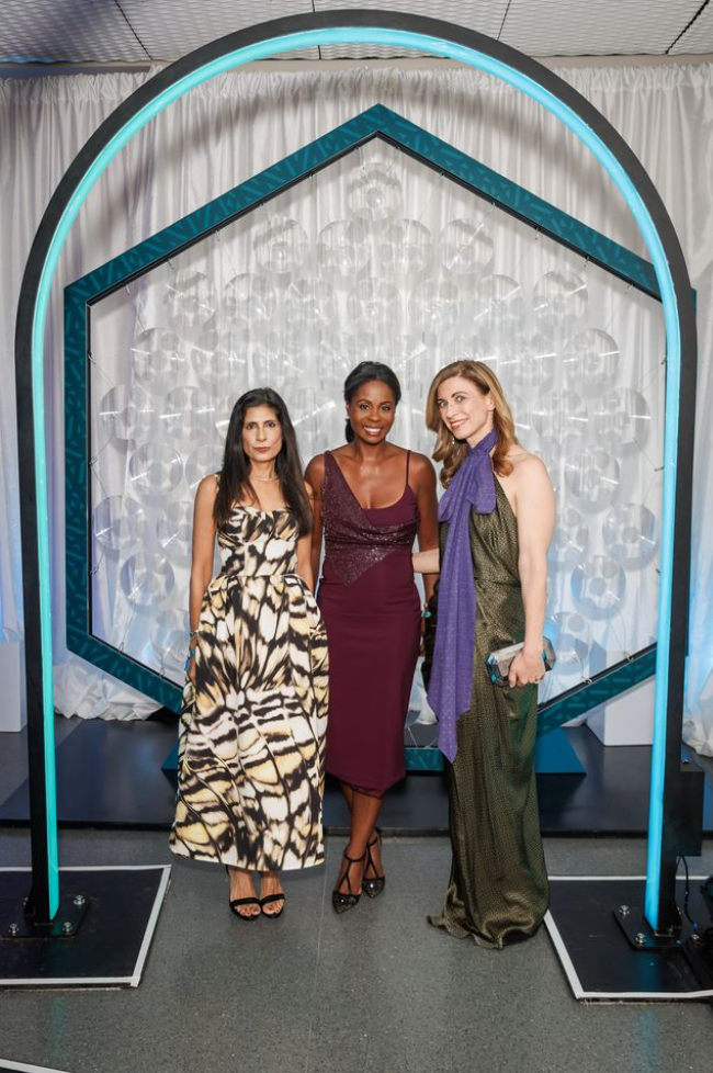 Three attendees posing at Art Bash 2026 at SFMOMA in evening dresses under geometric arch