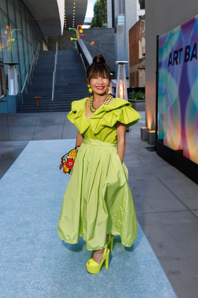 Guest posing at Art Bash 2026 at SFMOMA wearing bright green dress outside museum entrance