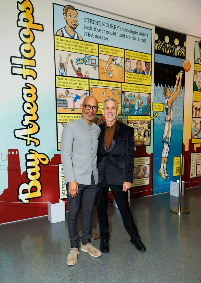 Two guests posing at Art Bash 2026 at SFMOMA in front of colorful exhibition wall