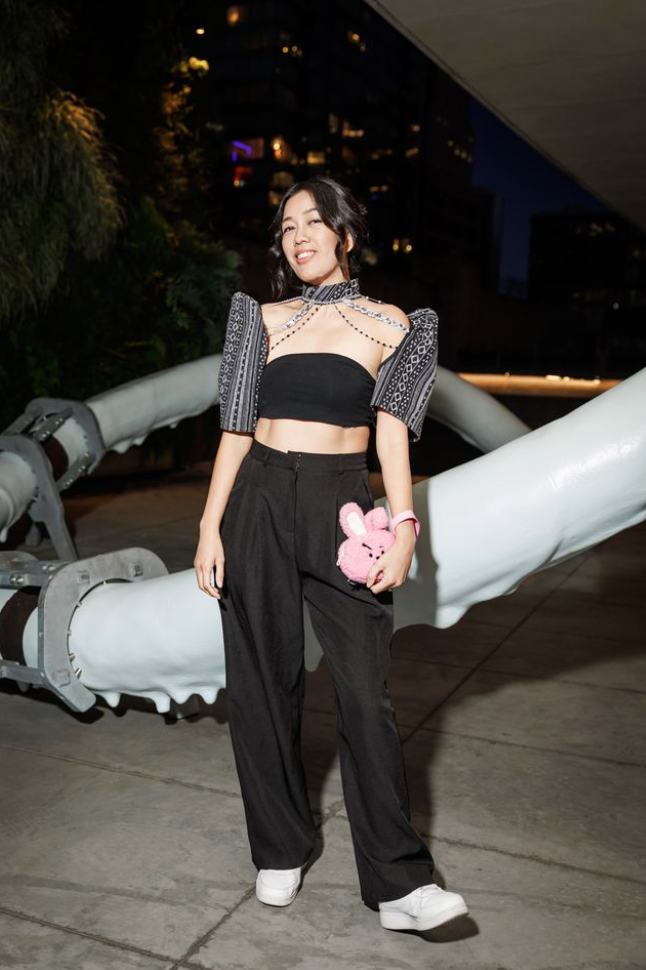 Guest posing on SFMOMA terrace at Art Bash 2026 wearing black outfit with pink accessory
